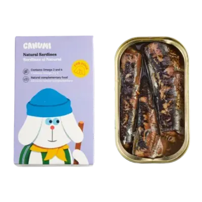 Thumbnail 400x400 for Lata abierta de sardinas naturales en conserva para perros junto a su empaque de la marca Canumi. El envase es de color lila con ilustración de un perro blanco con gorro azul y bufanda amarilla, destacando que el producto es un alimento complementario natural rico en Omega 3 y 6.