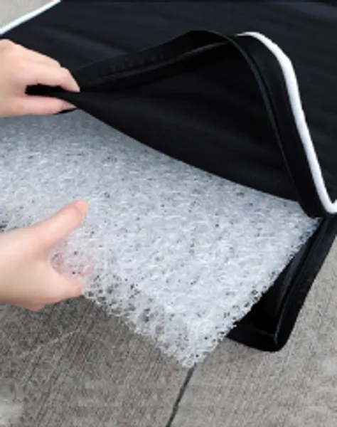 Manos mostrando el interior de la colchoneta para perro con material transpirable y funda desmontable fácil de limpiar