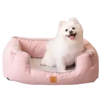 Thumbnail 200x200 for Perro blanco pequeño y esponjoso sentado en una Cama Ortopédica para Perros Luxury de color rosa, con bordes acolchados y diseño ergonómico para mayor comodidad.