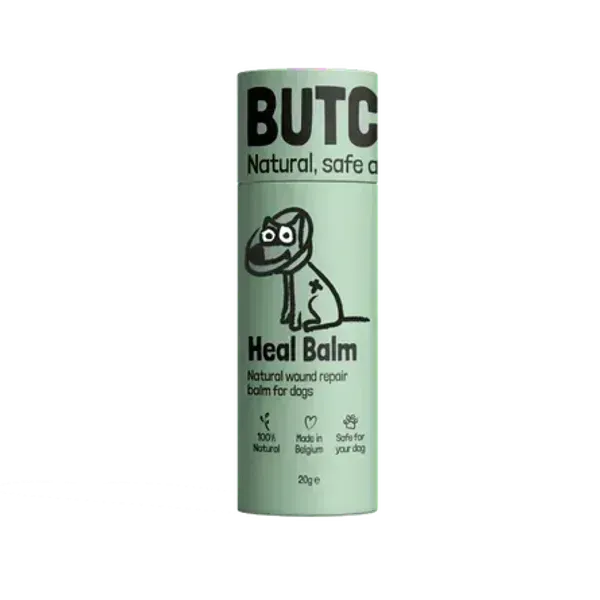 Envase del bálsamo Butchcare Heal Balm, un producto natural para la reparación de heridas en perros. Diseño minimalista en color verde claro con ilustración de un perro vendado y texto en negro.