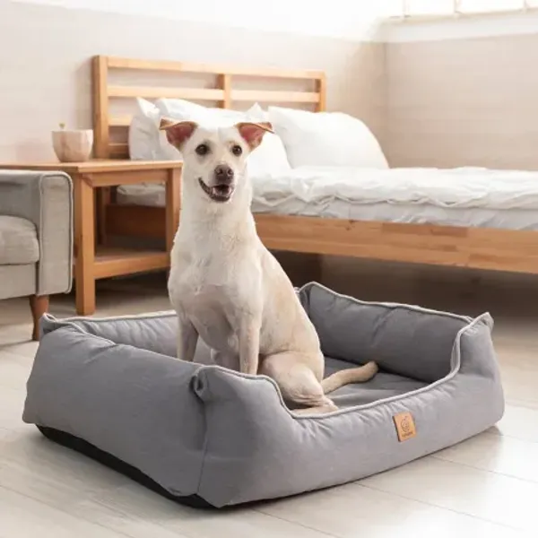 Perro relajado en una cama ortopédica Luxury gris, creada para reducir la presión en las articulaciones y ofrecer comodidad y apoyo ergonómico.