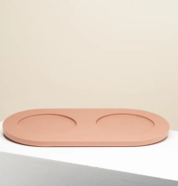 Base artesanal en color terracota para comedero y bebedero de perro pequeño o mediano. Fabricada con materiales sostenibles y superficie antideslizante para evitar movimientos y proteger el suelo. Diseño ovalado y hecho a mano. Apta para uso interior y exterior cubierto.