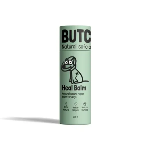 Envase cilíndrico verde claro de Heal Balm para perros, un bálsamo natural para la reparación de heridas. El diseño muestra un dibujo de un perro con un vendaje y los iconos indican que es 100% natural, hecho en Bélgica y seguro para los perros. El envase tiene un aspecto limpio y profesional sobre fondo blanco.